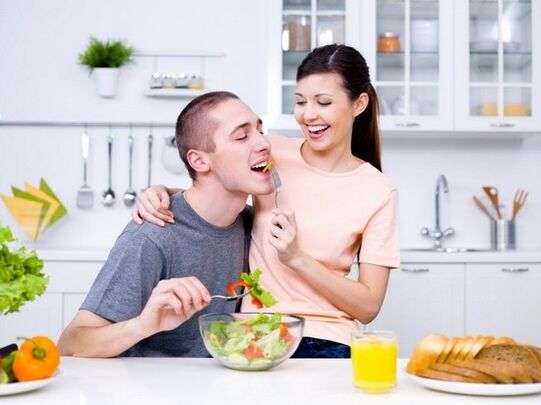 una mujer alimenta a un hombre con productos para aumentar la potencia de forma natural